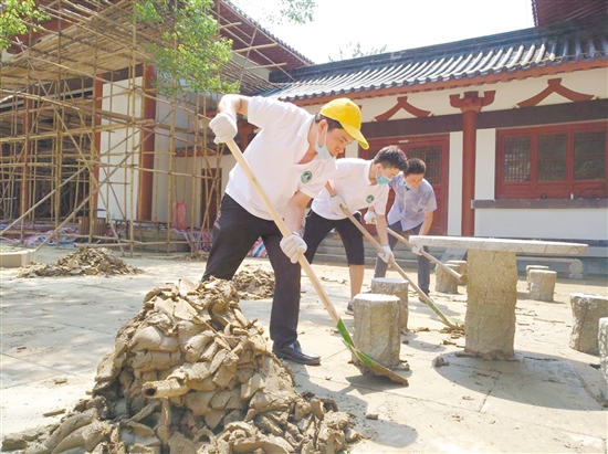 义工们分工合作铲走泥沙、搬走垃圾。